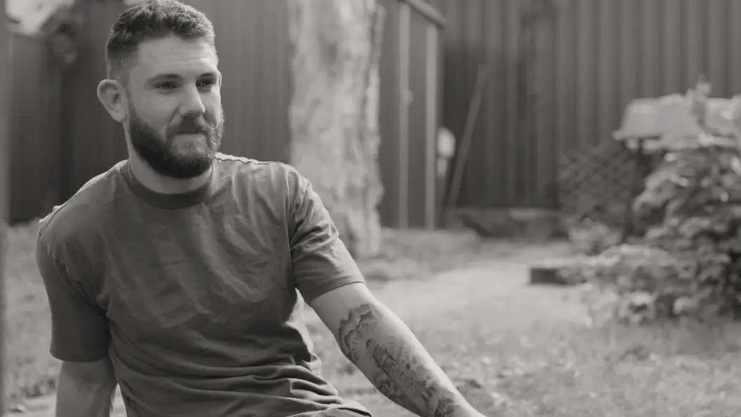 Portrait of man sitting in his backyard.