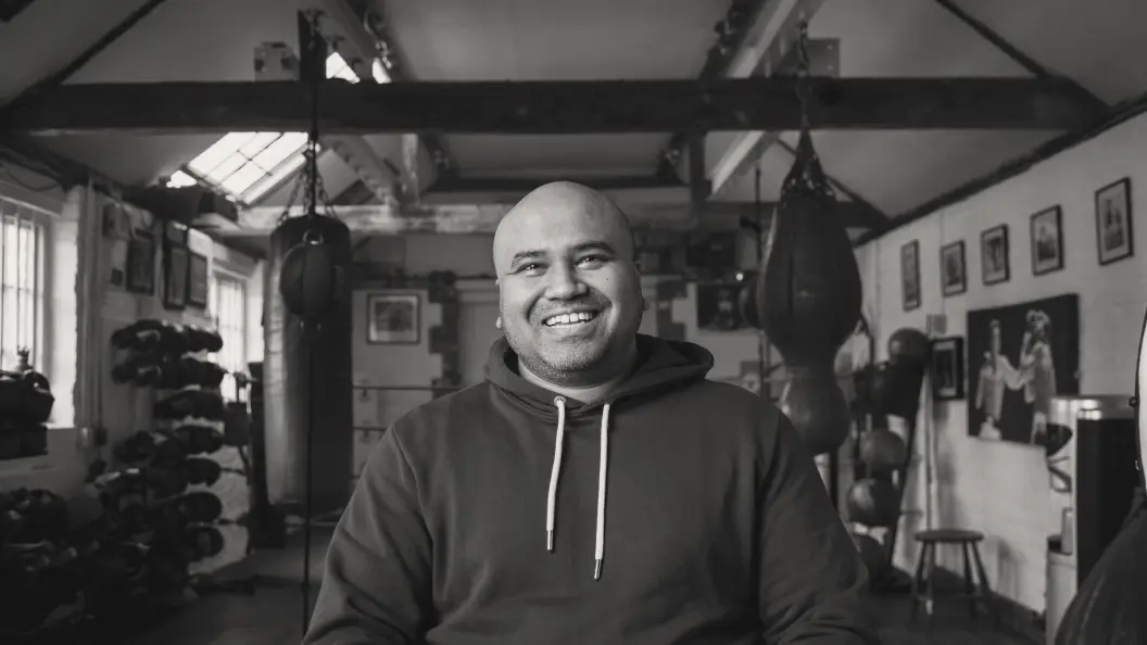 Portrait of man wearing hoodie in boxing gym.