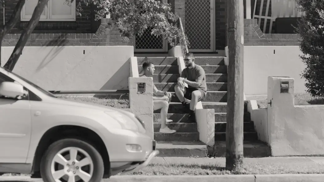 Two young men sitting on some steps and chatting to each other